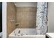 Close up of bathroom jacuzzi bathtub with tiled wall and modern shower curtain at 3549 N Sherman Dr, Indianapolis, IN 46218