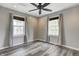 Bedroom with two windows providing natural light, ceiling fan, and modern gray vinyl plank flooring at 3549 N Sherman Dr, Indianapolis, IN 46218