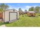 Backyard featuring sheds, garden beds, and green grass at 4152 S Creekside Dr, New Palestine, IN 46163