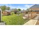 Backyard featuring deck, fire pit, sheds, and green grass at 4152 S Creekside Dr, New Palestine, IN 46163