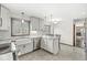 Well-lit kitchen features white cabinets, stone countertops, stainless steel appliances and a view to the breakfast nook at 4152 S Creekside Dr, New Palestine, IN 46163