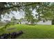 Lush backyard with trees, a shed, a deck with outdoor seating, and a wood pile at 431 Fox Cir, Noblesville, IN 46060