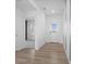 Hallway features wood-look flooring, white trim, and a clear view of the front door and adjacent room at 4985 W Burrel Ln, New Palestine, IN 46163
