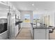 Bright kitchen with island, stainless steel appliances, and a view through the window at 4985 W Burrel Ln, New Palestine, IN 46163
