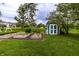 Lush backyard with a shed, swing set, and garden beds, ideal for outdoor activities at 5450 Fenmore Rd, Indianapolis, IN 46228