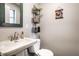 Well-lit bathroom featuring a sink, toilet, decorative mirror and wall decorations at 5450 Fenmore Rd, Indianapolis, IN 46228