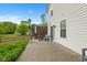 The back patio features a fire pit and outdoor seating, with a white fence and lush green trees in the background at 5550 Sweet River Dr, Indianapolis, IN 46221