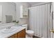 This bathroom has a shower-tub combo with a light striped shower curtain, and a vanity with dark wood cabinets at 5550 Sweet River Dr, Indianapolis, IN 46221