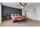 This main bedroom features a dark accent wall, ceiling fan and a leather bench at the foot of the bed at 5550 Sweet River Dr, Indianapolis, IN 46221