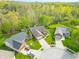 An aerial view shows the property's landscaped yard and its proximity to a lush wooded area at 5615 Burning Tree Ct, Indianapolis, IN 46239