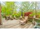 Expansive back deck with ample seating, an umbrella, and a view of the wooded yard at 5615 Burning Tree Ct, Indianapolis, IN 46239