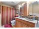 Bathroom featuring a double vanity with ample lighting, decorative striped shower curtain and tile floors at 5615 Burning Tree Ct, Indianapolis, IN 46239