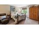 Bright bedroom with neutral walls and an iron bed frame, featuring a window view to the exterior at 5615 Burning Tree Ct, Indianapolis, IN 46239