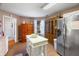 Charming kitchen with a white island, stainless steel refrigerator, and ample cabinet space at 5615 Burning Tree Ct, Indianapolis, IN 46239