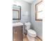 Bathroom with sleek vanity, mirror, and wood-trimmed windows. Toilet offers a comfortable seat at 5901 W Thompson Rd, Indianapolis, IN 46221
