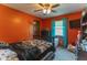 Bedroom with orange walls, and a ceiling fan. Natural light from the window gives the room a nice bright feeling at 5901 W Thompson Rd, Indianapolis, IN 46221