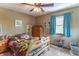 Cozy bedroom featuring a ceiling fan, natural light, and a comfortable bed covered with plush stuffed animals at 5901 W Thompson Rd, Indianapolis, IN 46221