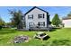 Backyard view of house, deck, picnic table and firepit area on a sunny day at 609 Delray Dr, Indianapolis, IN 46241