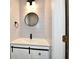 Charming bathroom featuring a vanity with white countertop, black faucet, and modern round mirror at 609 Delray Dr, Indianapolis, IN 46241