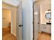 Hallway with two open doors, leading to a stylish bathroom and another room at 609 Delray Dr, Indianapolis, IN 46241