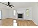 Cozy living room features a fireplace with brick surround and modern ceiling fan, enhancing the room's charm at 609 Delray Dr, Indianapolis, IN 46241