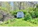 Storage shed surrounded by lush greenery, nestled in the backyard at 609 Delray Dr, Indianapolis, IN 46241