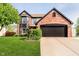 Charming two-story brick home featuring a well-manicured lawn and an attached two-car garage at 6144 Black Oaks Way, Indianapolis, IN 46237