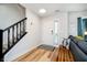 Bright foyer featuring hardwood floors, stairs with black wood railing and a white front door at 6144 Black Oaks Way, Indianapolis, IN 46237