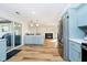 Bright kitchen boasts stainless steel appliances, an island, and hardwood floors leading into the living room at 6144 Black Oaks Way, Indianapolis, IN 46237
