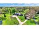 Stunning aerial view of a home with a circular driveway, lush green lawn, and mature trees on a sunny day at 6149 W Olive Branch Rd, Greenwood, IN 46143