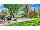 Backyard featuring a basketball court, patio with grill, and lush green trees at 6149 W Olive Branch Rd, Greenwood, IN 46143