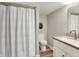 A clean bathroom with a shower and curtain, wood-look floors, and a single sink vanity with a light countertop at 6149 W Olive Branch Rd, Greenwood, IN 46143
