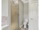 Bathroom with updated shower featuring patterned glass door, tiled accent, and toilet with built-in storage at 6149 W Olive Branch Rd, Greenwood, IN 46143