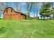 A detached wooden garage stands on a sprawling green lawn, with the main house visible in the background at 6149 W Olive Branch Rd, Greenwood, IN 46143