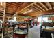 Spacious garage featuring an orange tractor, golf cart, and wooden beam construction at 6149 W Olive Branch Rd, Greenwood, IN 46143