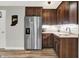 A kitchenette with stainless steel appliances, dark wood cabinets and decor on the white tiled backsplash at 6149 W Olive Branch Rd, Greenwood, IN 46143