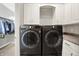 Laundry room featuring modern, front-loading washer and dryer with built-in cabinets for storage at 6149 W Olive Branch Rd, Greenwood, IN 46143