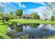Beautiful home and pond with lush green lawn, framed by mature trees and a reflective pond at 6149 W Olive Branch Rd, Greenwood, IN 46143