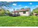 Home exterior with a well-kept lawn, back deck, mature trees, and a serene backyard setting at 6257 Old Barn Ct, Indianapolis, IN 46268