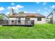 Home exterior featuring a backyard deck, lush green lawn, privacy fence, and tidy landscaping at 6257 Old Barn Ct, Indianapolis, IN 46268