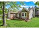 Inviting home exterior with brick accents, lush green lawn, and mature landscaping creates a warm and welcoming atmosphere at 6257 Old Barn Ct, Indianapolis, IN 46268