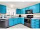 A kitchen boasts black appliances and bright robin's egg blue cabinetry with light countertops at 6257 Old Barn Ct, Indianapolis, IN 46268