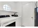 This tidy laundry room is equipped with a GE washer/dryer and features natural light from an octagonal window at 6257 Old Barn Ct, Indianapolis, IN 46268