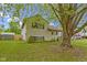 A well-manicured lawn surrounds this cozy two-story home, shaded by a large tree in the front yard at 6638 Sunbury Dr, Indianapolis, IN 46241