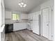 Bright kitchen featuring white cabinets, modern appliances, gray vinyl floors and vaulted ceiling at 6638 Sunbury Dr, Indianapolis, IN 46241