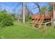 Backyard with a wooden deck and stairs surrounded by a green lawn and fenced area at 7002 N Ralston Ave, Indianapolis, IN 46220