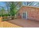 Wooden deck attached to a brick home overlooking the lush, green backyard with mature trees at 7002 N Ralston Ave, Indianapolis, IN 46220