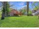 Large grassy backyard with a deck, mature trees, and well-maintained lawn at 7002 N Ralston Ave, Indianapolis, IN 46220