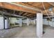 Unfinished basement with concrete flooring, block walls, exposed pipes, and a water heater at 7002 N Ralston Ave, Indianapolis, IN 46220