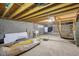Unfinished basement featuring exposed ceiling beams and cinder block walls with a washing machine at 7002 N Ralston Ave, Indianapolis, IN 46220
